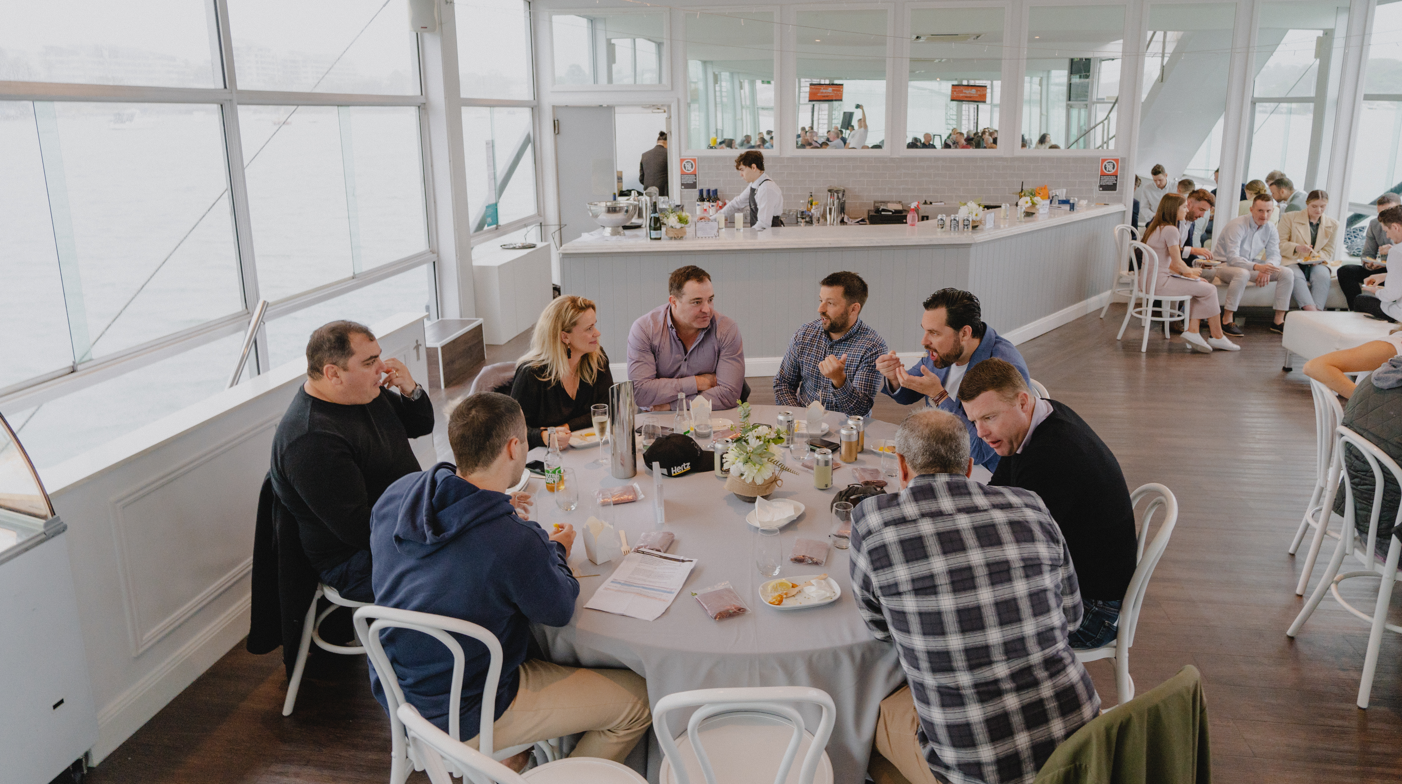 Group of men and women around table at an event at Starship Aqua on Sydney Harbour